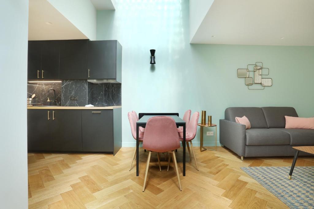 eine Küche und ein Wohnzimmer mit einem Tisch und Stühlen in der Unterkunft Apartment center of Paris by Studio prestige in Paris