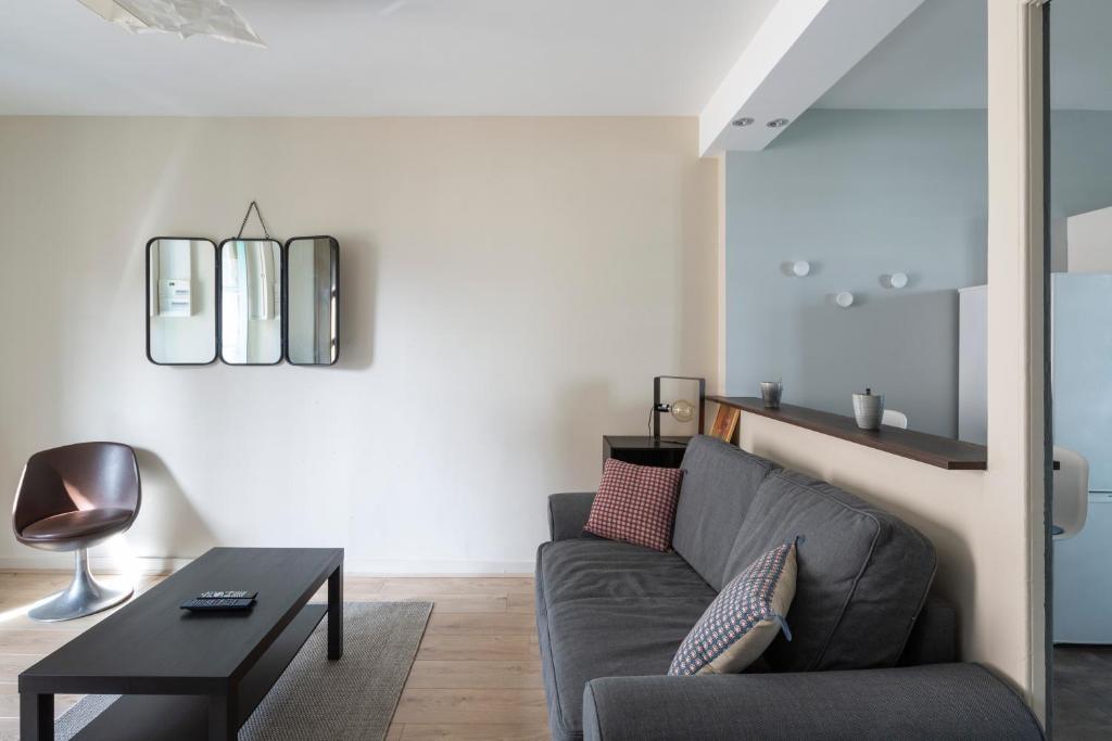 ein Wohnzimmer mit einem Sofa und einem Tisch in der Unterkunft Côté Rivière in Rennes