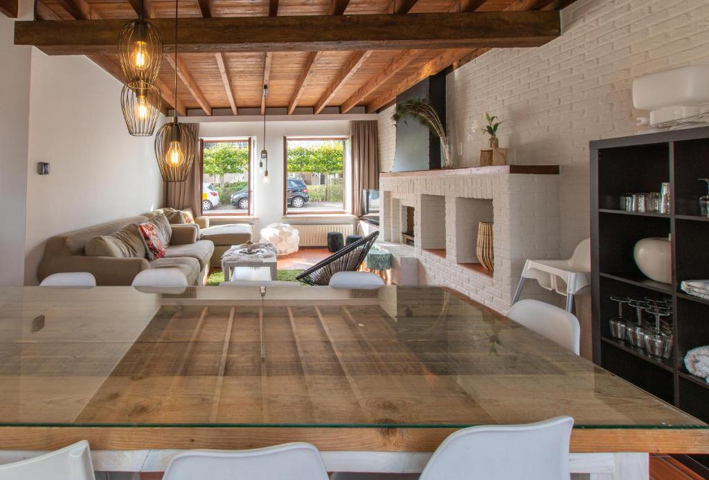 De Bosrand في Ichtegem: طاولة خشبية كبيرة في غرفة المعيشة مع أريكة