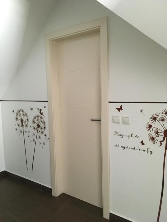 Zimmer mit einer Tür mit Löwenzahn an der Wand in der Unterkunft APARTMA AJDA in Kranj