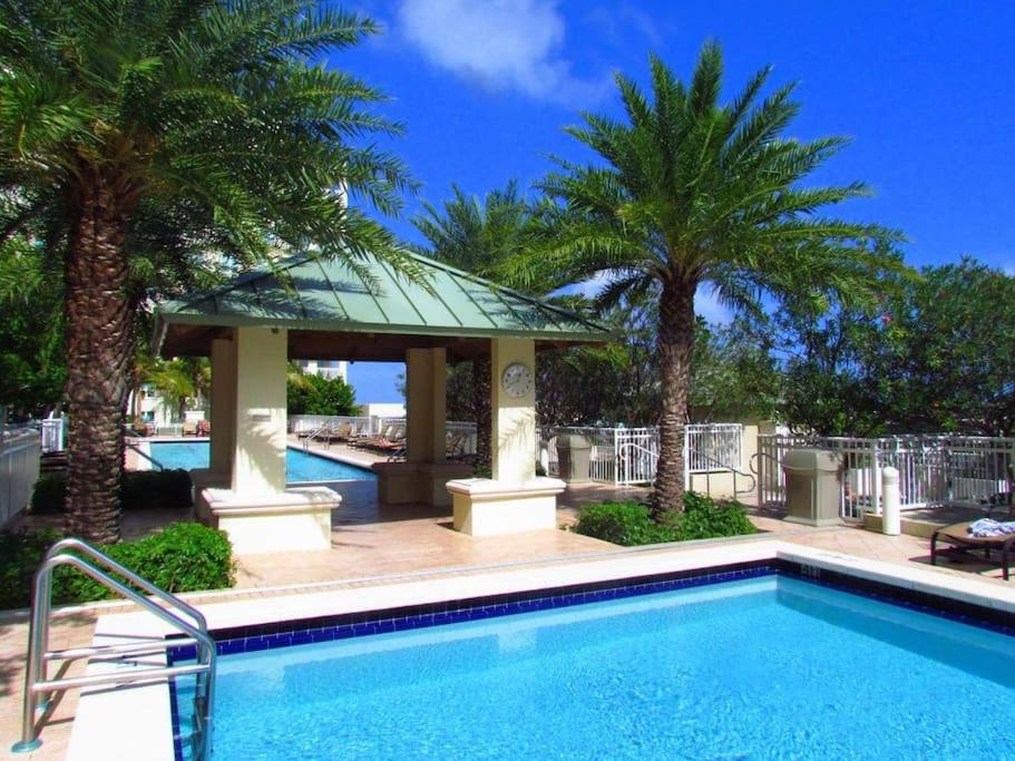 a swimming pool with palm trees and a gazebo at One Bedroom In Amazing Condobeach Pass Included! in Boynton Beach