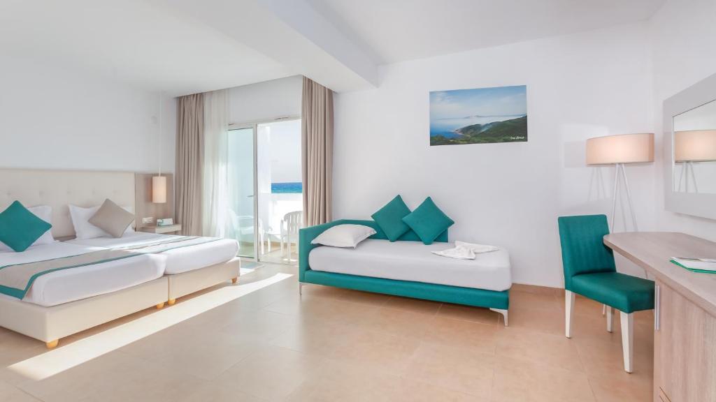 a hotel room with two beds and a desk at Hotel Nour Congress & Resort in Bizerte
