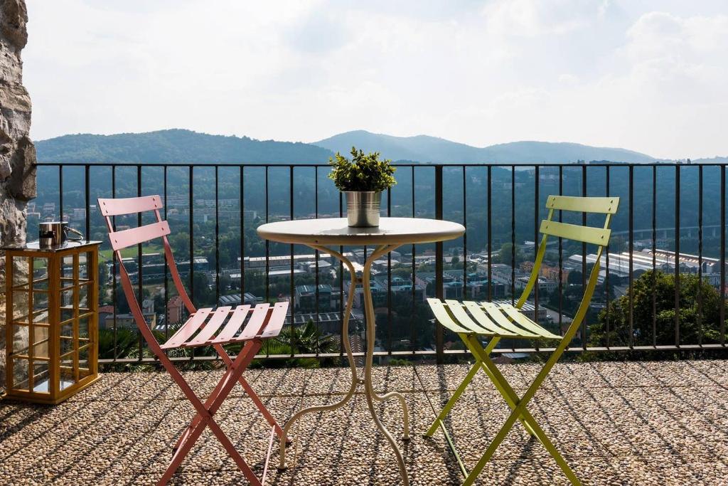 three chairs and a table on a balcony with a view at JOIVY Scenic 2BR Apt with Balcony & Parking in Cernobbio