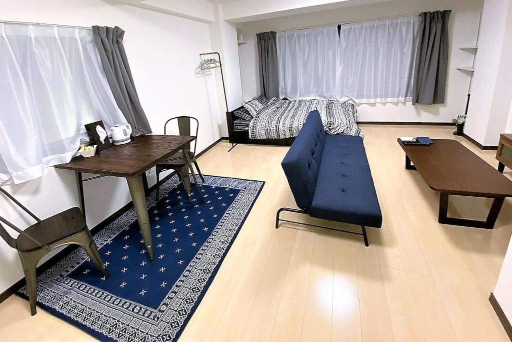 salon ze stołem i niebieską kanapą w obiekcie 002.Standard Number w mieście Kumamoto