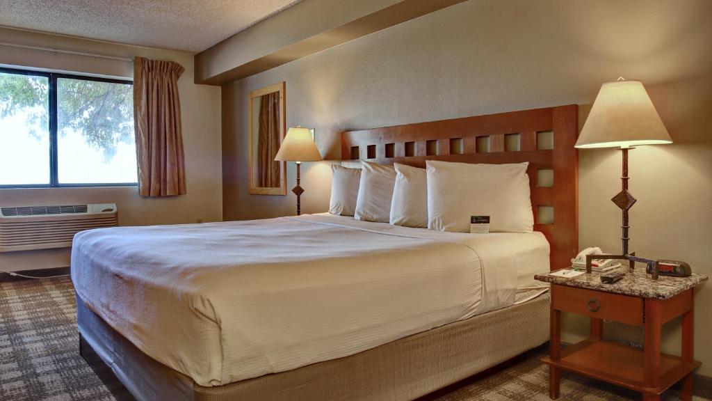 GreenTree Inn Albuquerque North I-25 في ألباكيركي: غرفة فندقية بسرير كبير ونافذة