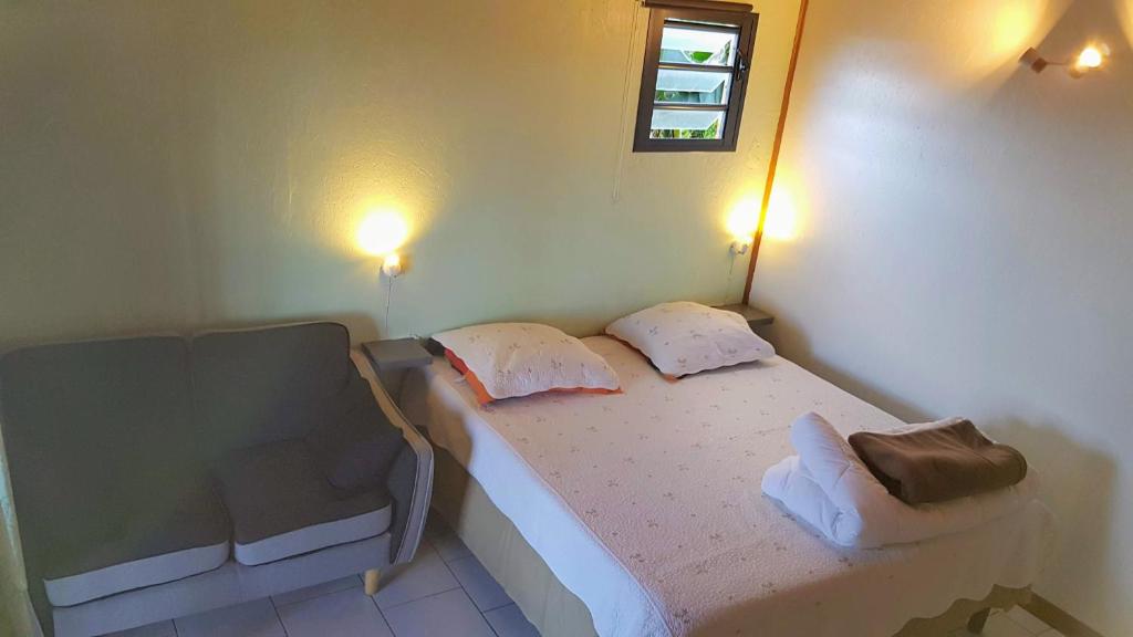 um pequeno quarto com uma cama e uma cadeira em Le petit chalet em LʼEscalier