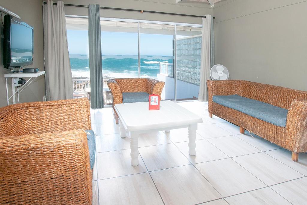 a living room with a couch and a table with chairs at Point Village Hotel and Self Catering in Mossel Bay