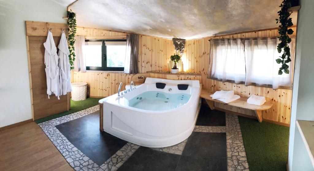 a large bath tub in a room with wooden walls at REnt Room Wood in Anguillara Sabazia