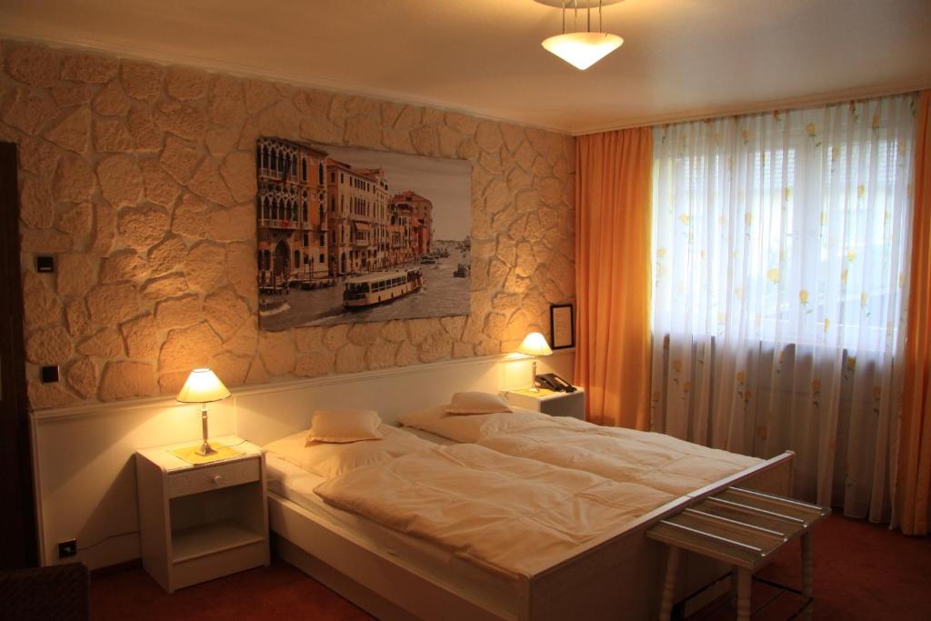 um quarto com uma cama, 2 candeeiros e uma janela em Hotel Die Post em Offenbach