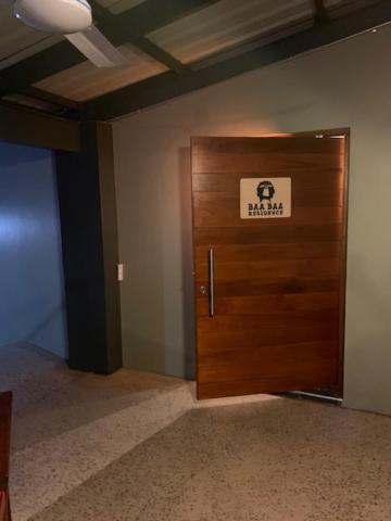Una puerta de madera en una habitación con un cartel. en BAA BAA RESIDENCE, en Hillcrest