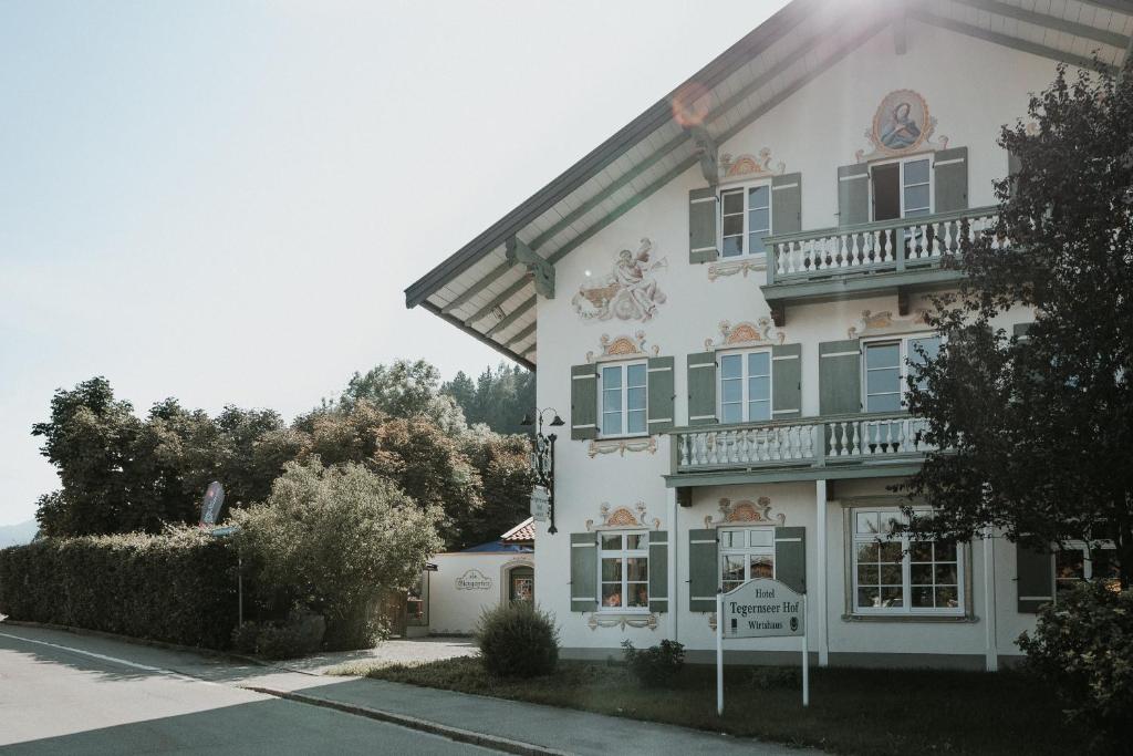 um edifício branco com uma varanda ao lado em Tegernseer Hof em Gmund am Tegernsee