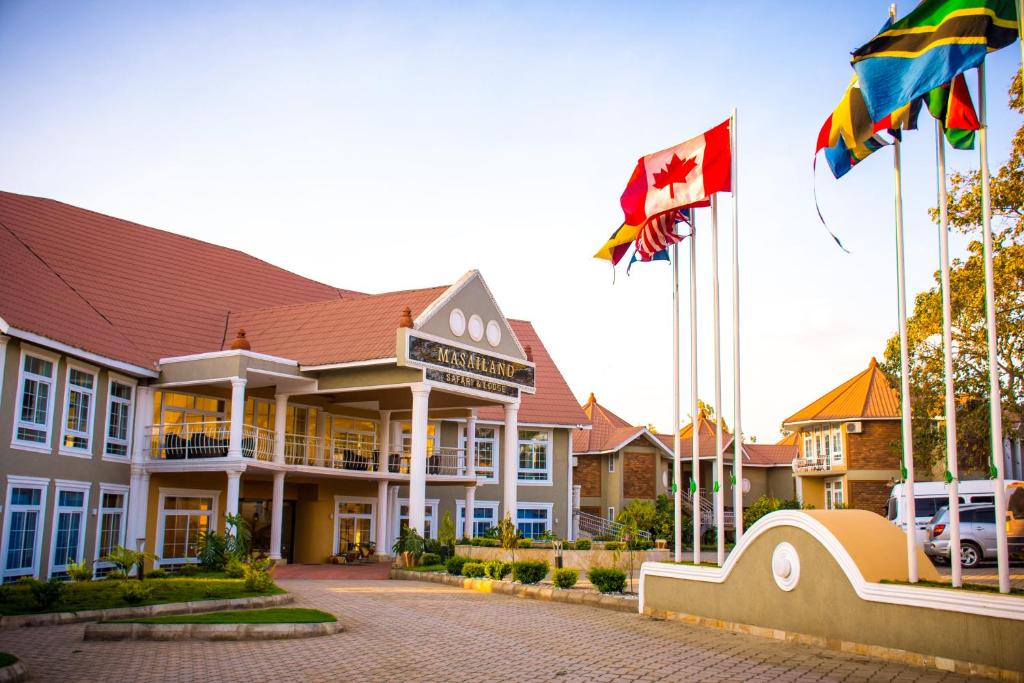 un hotel con banderas frente a un edificio en Masailand Safari Lodge en Arusha