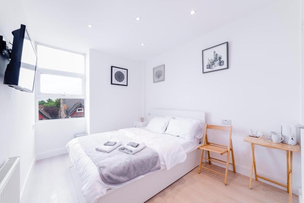Habitación blanca con cama y ventana en Quiet cosy rooms, en Harrow