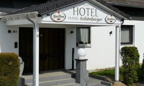 un hotel con un cartel en la parte delantera de un edificio en Hotel Garni Haus Schönberger, en Heiligenhaus
