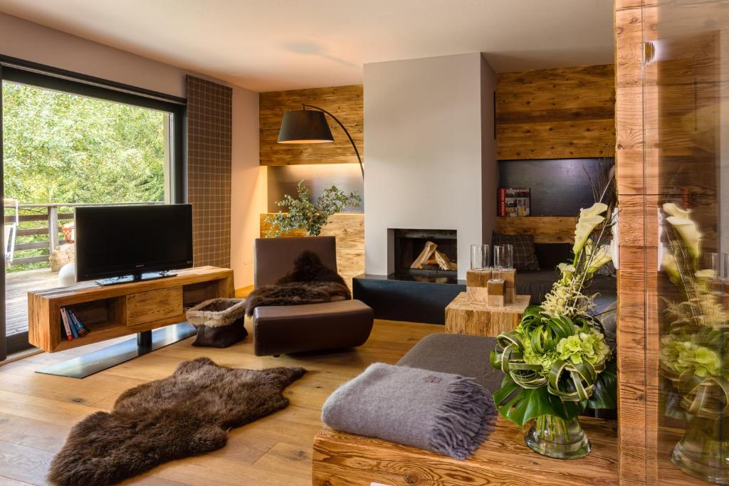 a living room with a fireplace and a tv at Chalet Avidea Secret in Avelengo