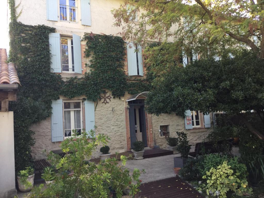 a house with ivy on the side of it at Le clos d'André in Castelnaudary