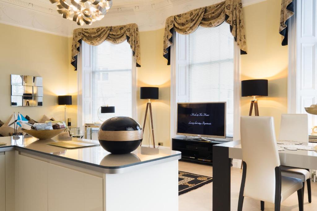 a living room with a desk and a television at Marks at The Manor Luxury Riverside Apartments - Sleeps up to 4, with Parking and Wi-Fi in Aberdeen