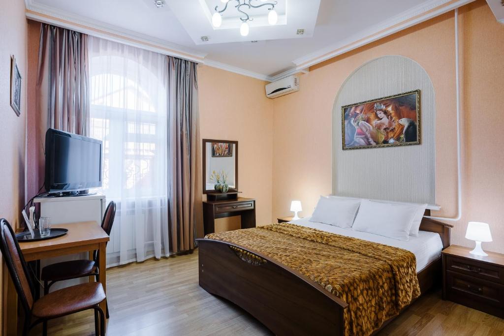 Habitación de hotel con cama y TV en Hotel 21 Vek, en Astrakhan
