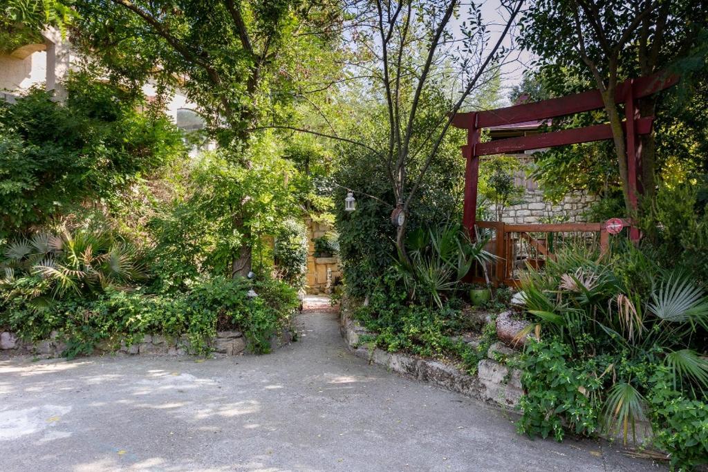 un jardín con una puerta y árboles y plantas en Jardin et bambous, studio cosy, classé 2 étoiles, en Marseillan