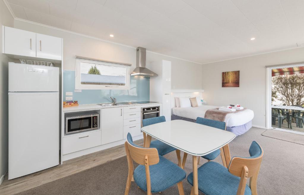 a kitchen with a bed and a table and chairs at Abbey Court Motel in Motueka