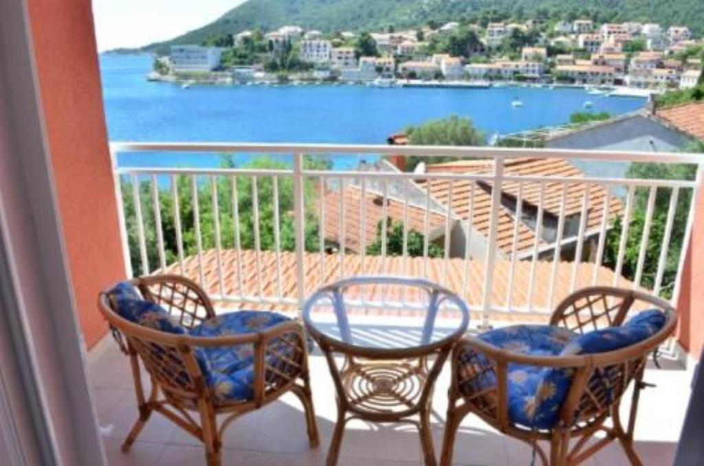 trzy krzesła i stół na balkonie z widokiem w obiekcie Bleus Apartments w mieście Brna