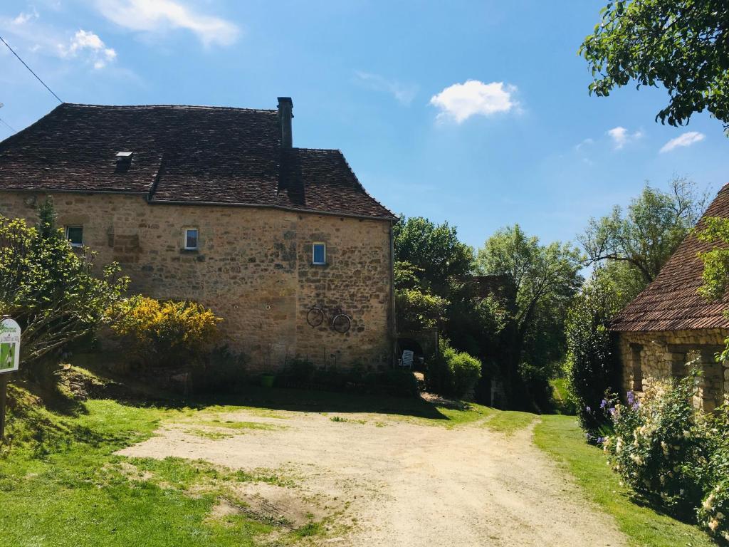 an old stone house on a dirt road at Gîte et chambres d'hôtes - Sur le chemin des sens in Azerat
