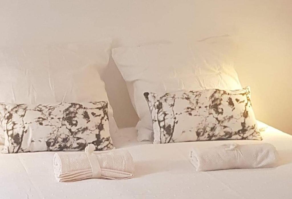 ein weißes Bett mit zwei Kissen und einem Handtuch darauf in der Unterkunft Carré Saint-Gervais Rouen centre in Rouen