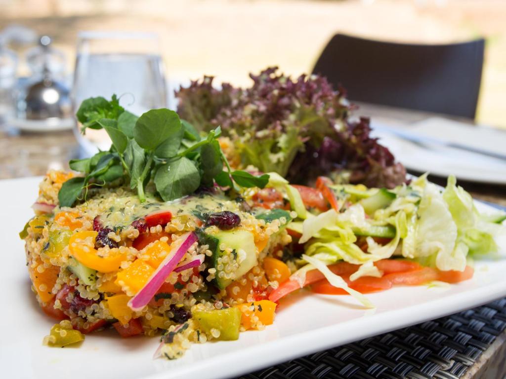 a plate of food with a salad on a table at Shepherds Tree Game Reserve in Pilanesberg