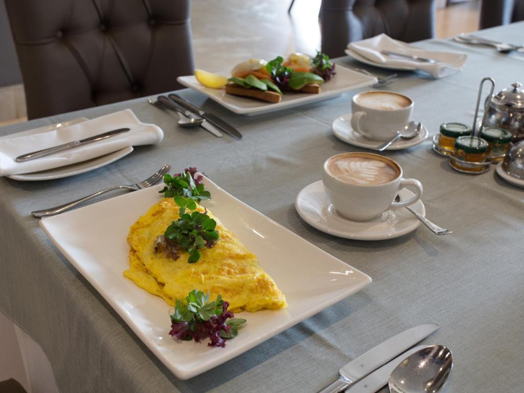 a table with a plate of food and a cup of coffee at Shepherds Tree Game Reserve in Pilanesberg