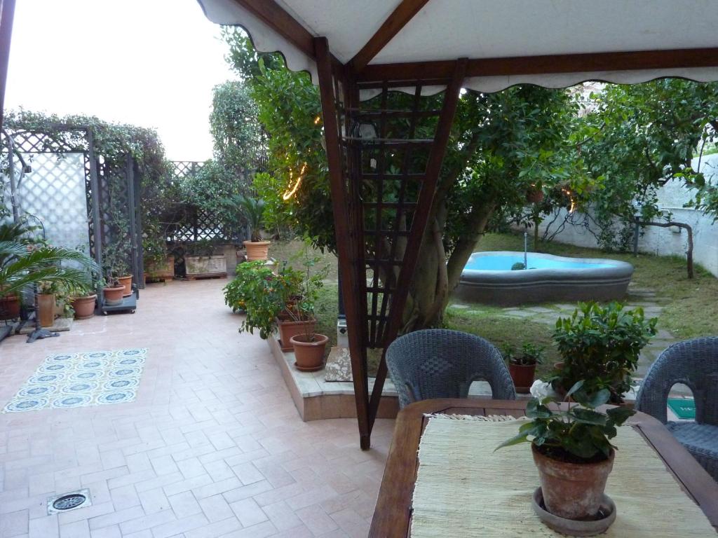 eine Terrasse mit einem Tisch, Stühlen und einem Pool in der Unterkunft Posillipo Super Mono in Neapel