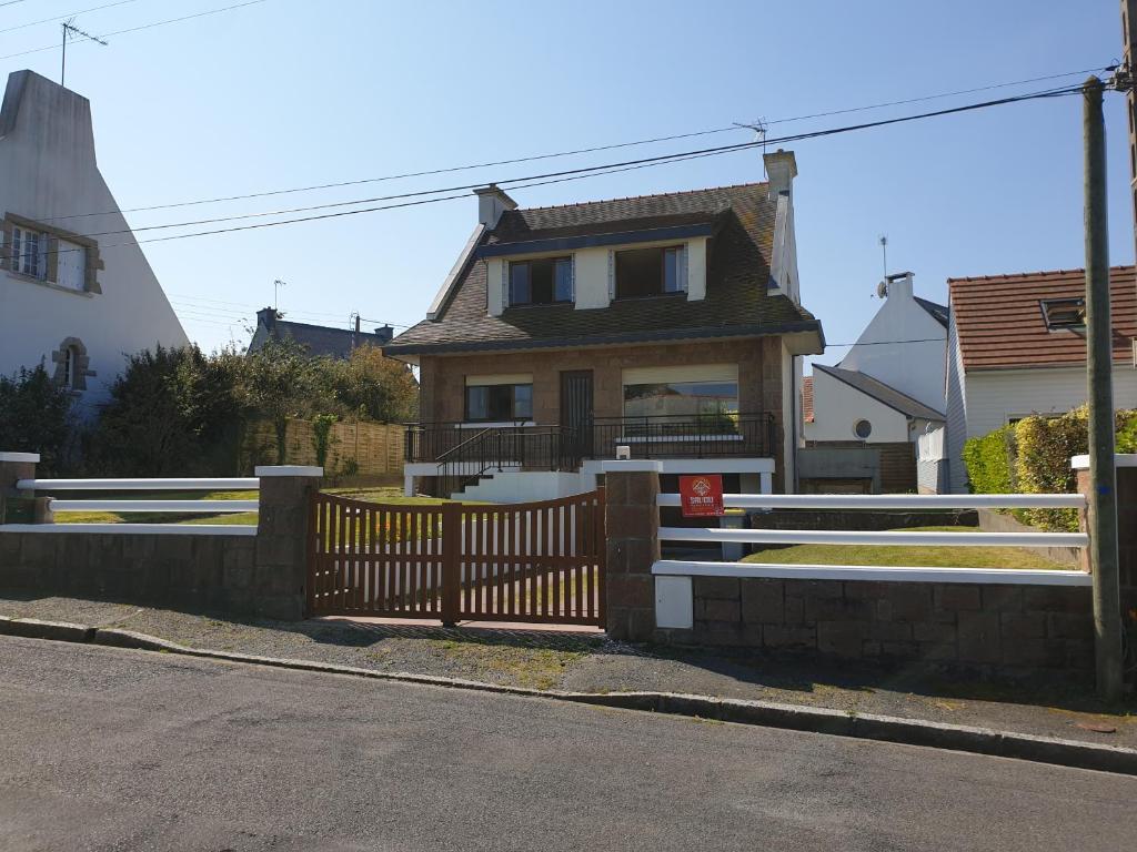 a house with a wooden gate and a fence at The Cuban & SPA Privé in Perros-Guirec