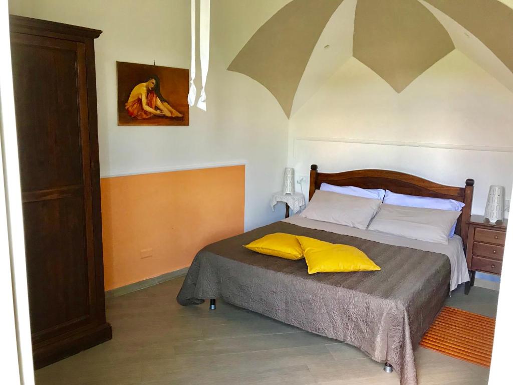 1 dormitorio con 1 cama con 2 almohadas amarillas en Casette sul Porto, en Isquia
