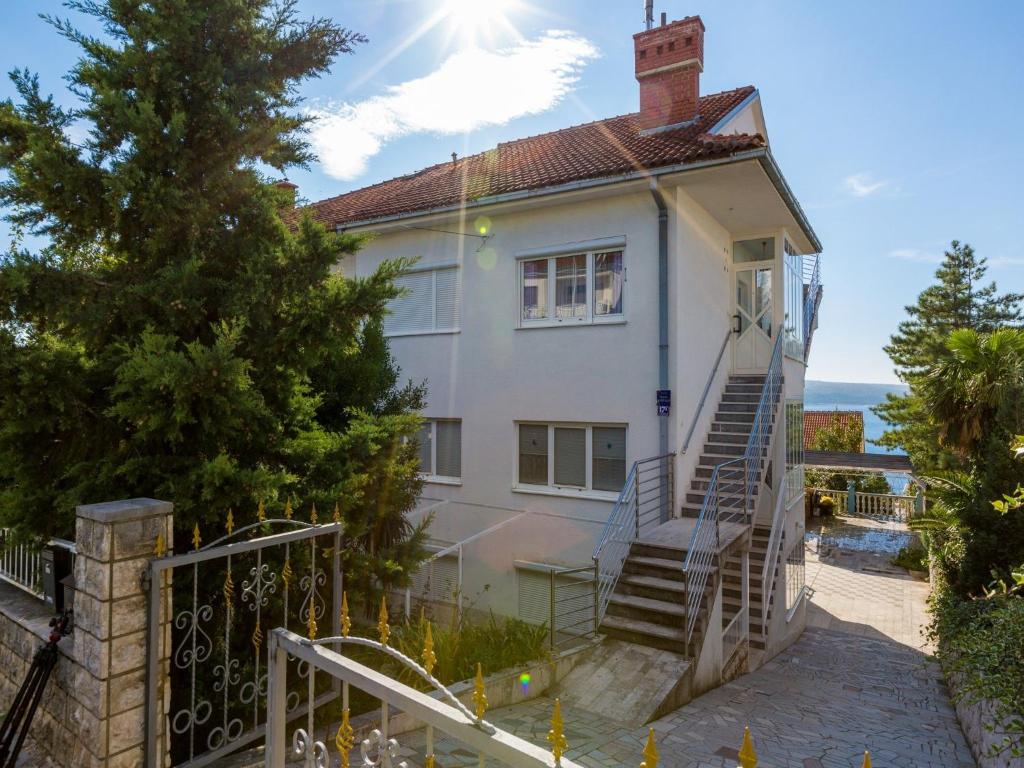 a white house with stairs leading to the ocean at Apartments Dubravka in Crikvenica