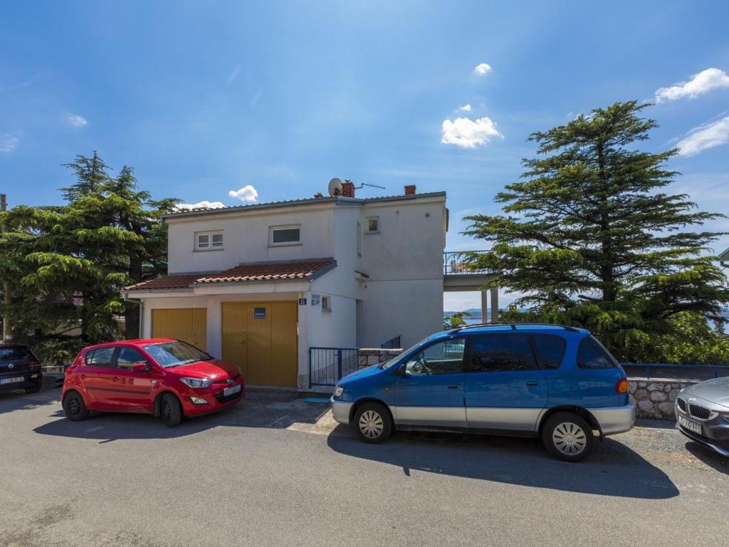 two cars parked in a parking lot in front of a house at Apartments Maro in Dramalj