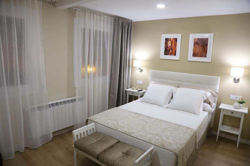1 dormitorio con 1 cama blanca grande y 1 silla en Aires do Umia, en Caldas de Reis