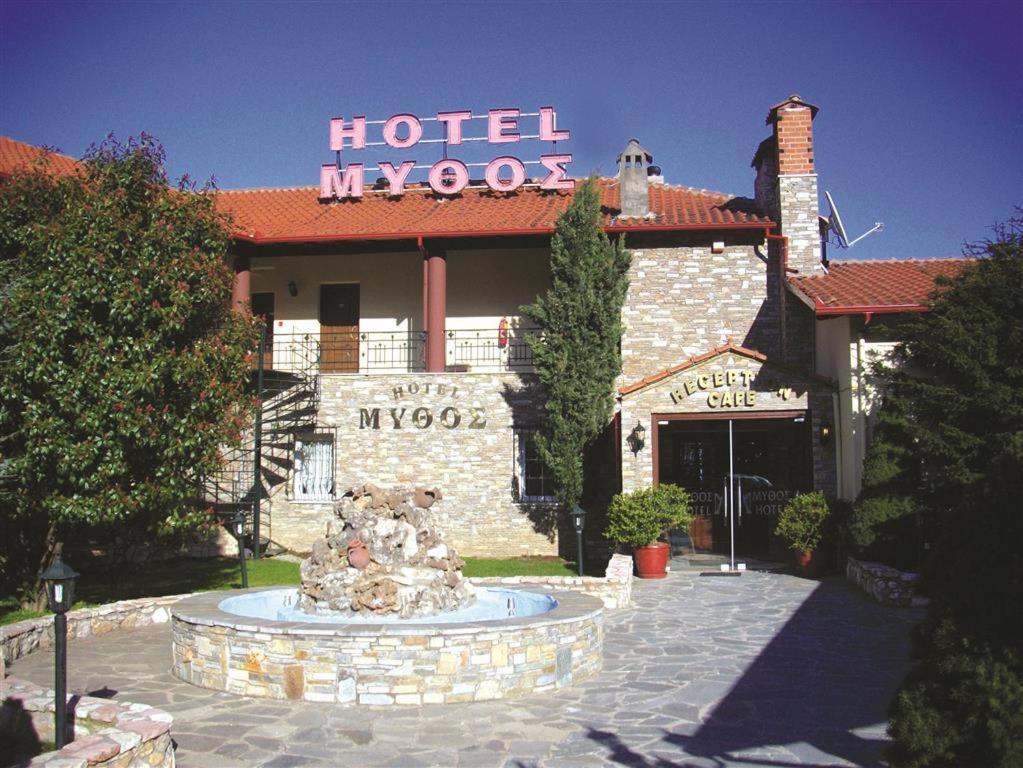 un hotel con una fontana di fronte a un edificio di Mythos a Elatochori (Elatochórion)
