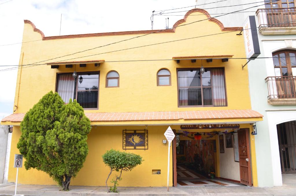 żółty budynek na rogu ulicy w obiekcie Hotel Posada Escudero w mieście Oaxaca