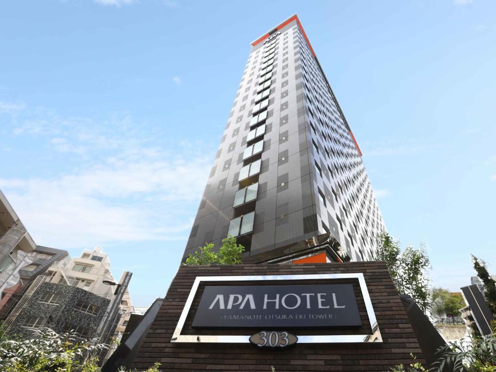 a hotel sign in front of a tall building at APA Hotel Yamanote Otsuka Eki Tower in Tokyo