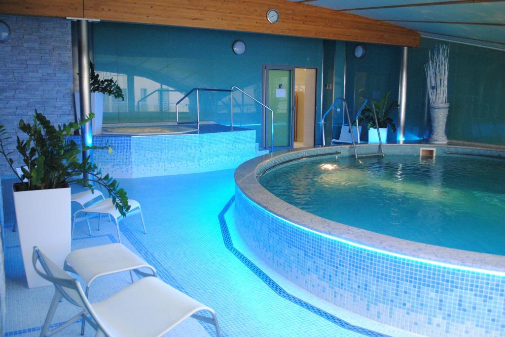 a large swimming pool with chairs in a building at Venus in Karlovy Vary