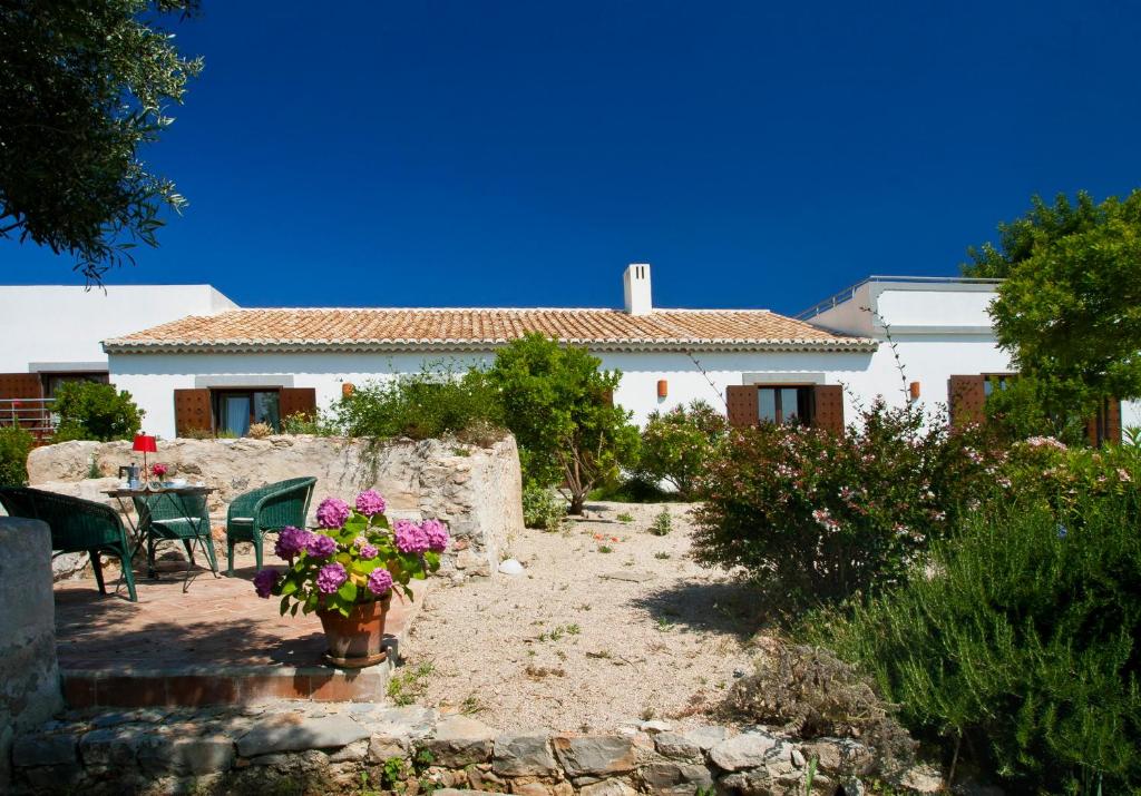 uma casa com mesa, cadeiras e flores em Monte Do Alamo - Turismo Rural em Tavira