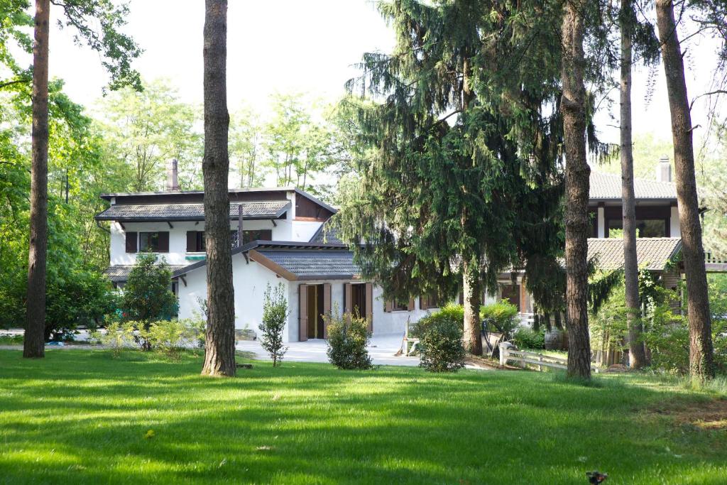 une maison blanche avec des arbres dans la cour dans l'établissement Sant'Anna, à Somma Lombardo