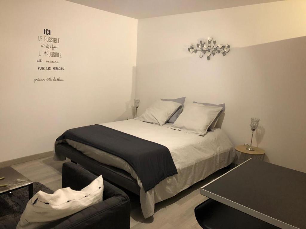 - une petite chambre avec un lit et une table dans l'établissement Beau Studio M Euroairport Basel-Freiburg, à Saint-Louis