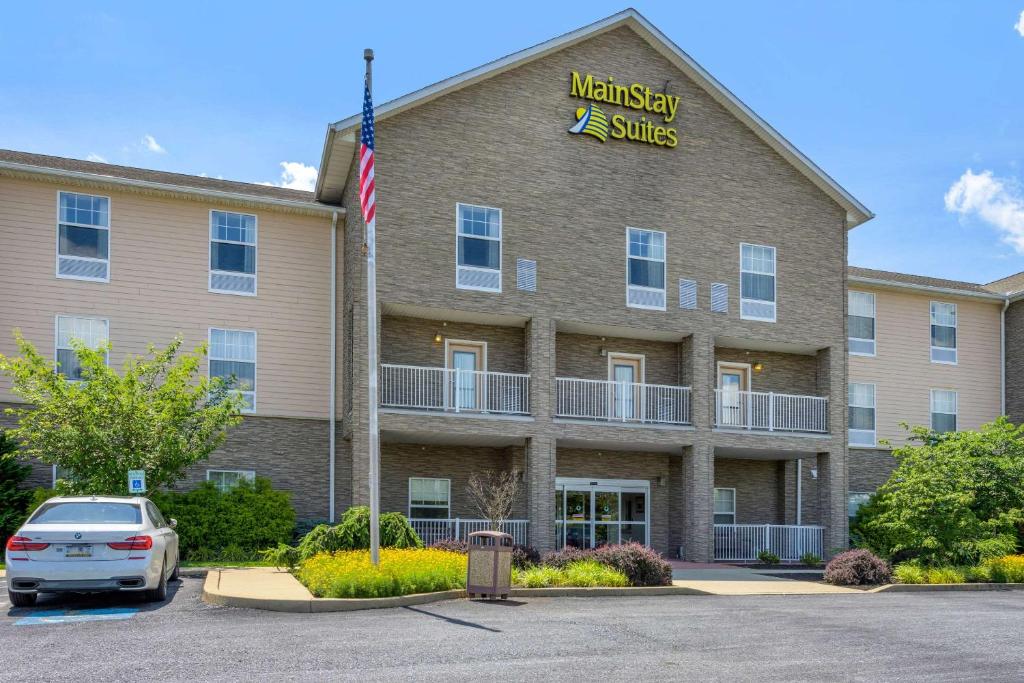 un bâtiment avec une voiture garée devant lui dans l'établissement MainStay Suites Grantville, à Grantville