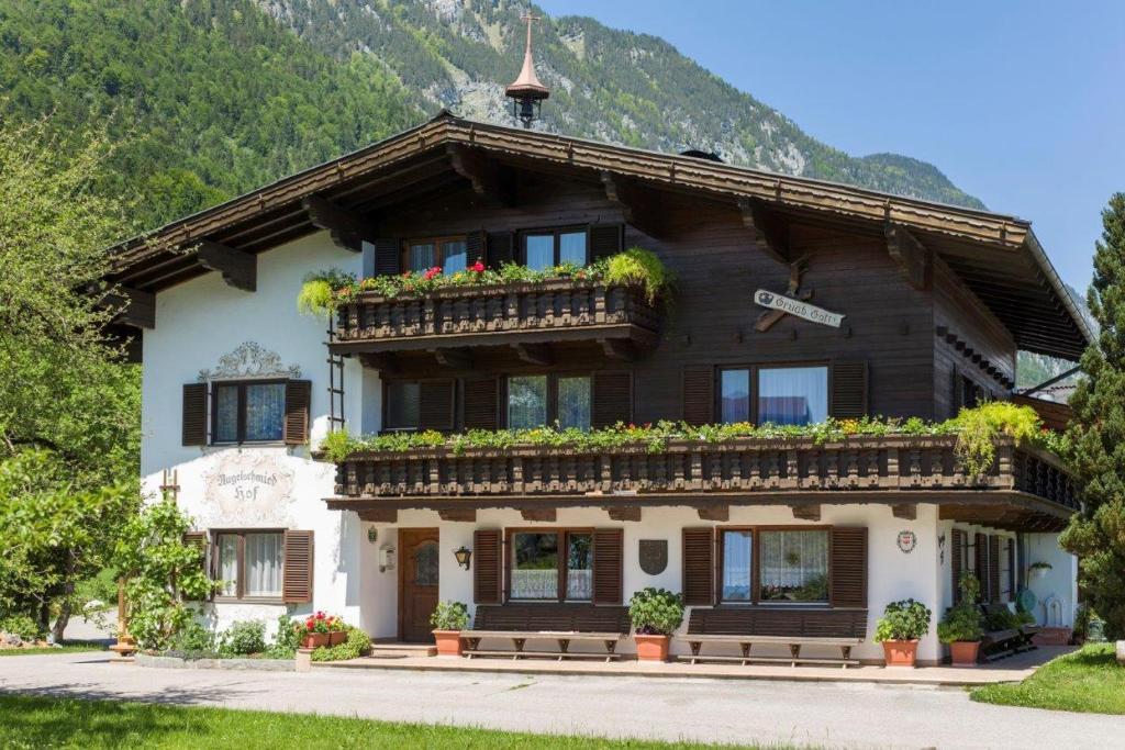 a house with flowers on the balconies of it at Bauernhof Nagelschmiedhof in Langkampfen