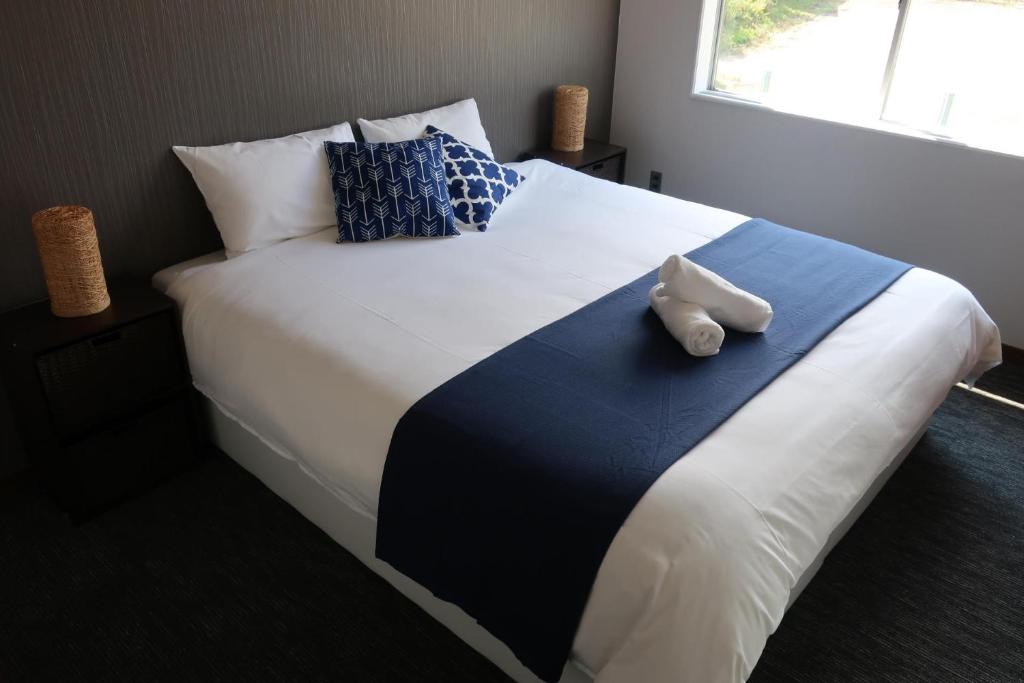 łóżko z dwoma białymi butami siedzącymi na nim w obiekcie Starfall Lodge w mieście Hakuba