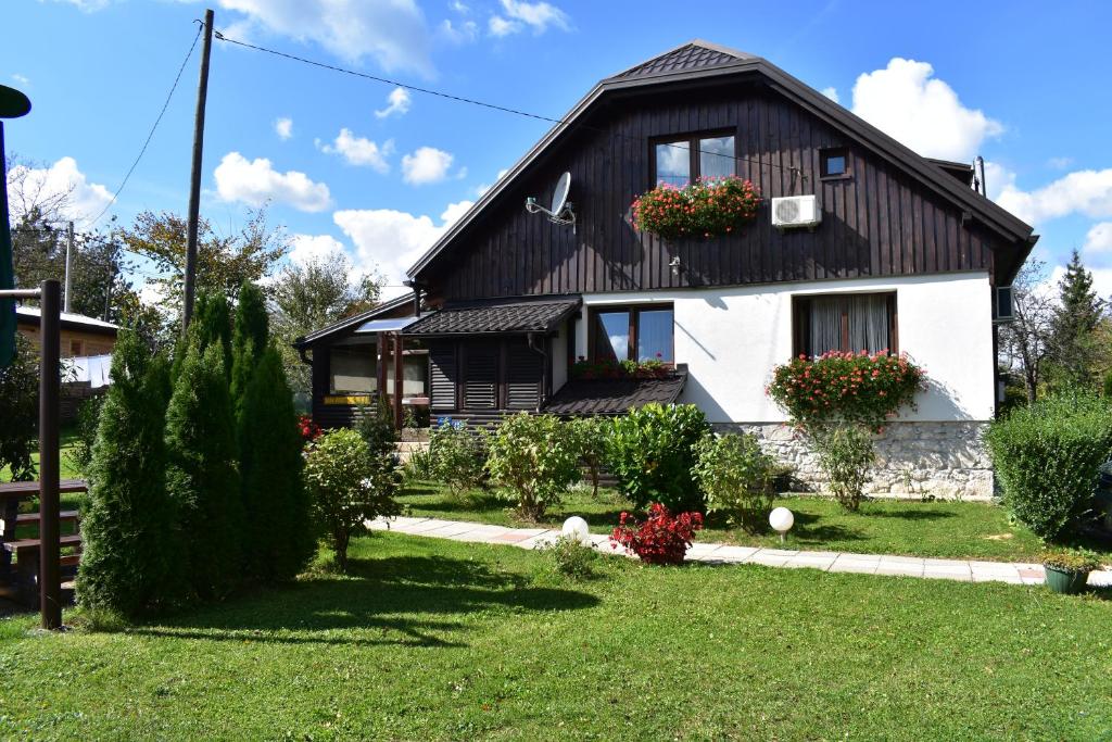 een huis met een zwart dak bij Rada Guest House in Plitvička Jezera