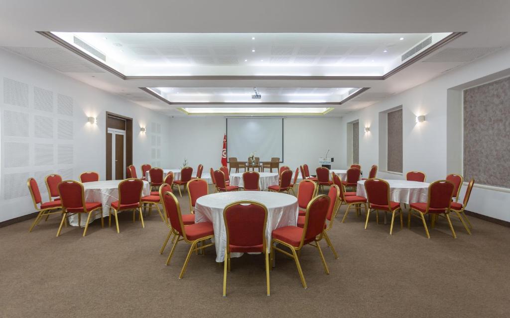 a conference room with tables and chairs and a podium at Hotel Nour Congress & Resort in Bizerte