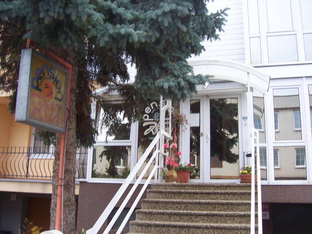 a house with stairs leading to a door with a tree at Pension Zita in Znojmo