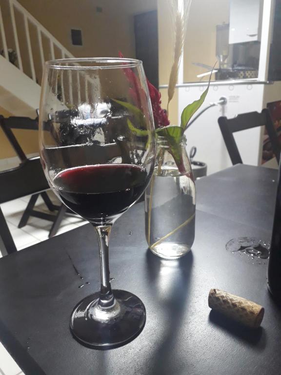 a glass of red wine sitting on a table at Vila do Chaves bed breakfast in Sao Paulo