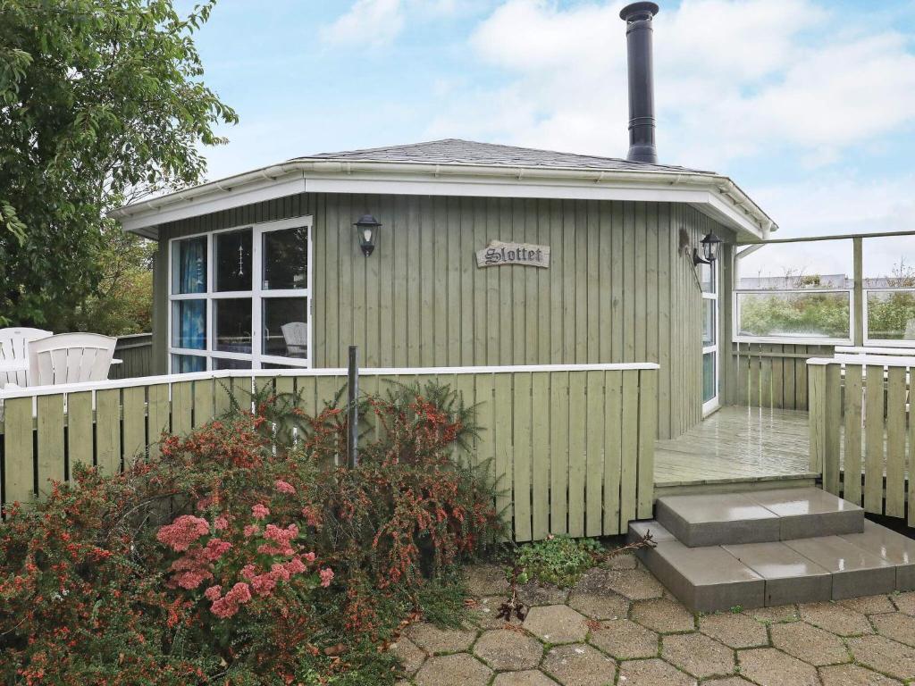 uma casa verde com uma cerca e um alpendre em 4 person holiday home in Vinderup em Vinderup